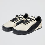 White sneakers with black soles and laces on a light gray background