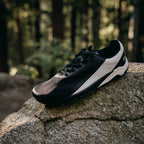 Black and white sneaker on a rock with a forest background